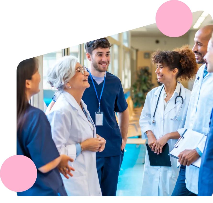 A group of care workers and nurses smiling and discussing the adult care community apprenticeship.